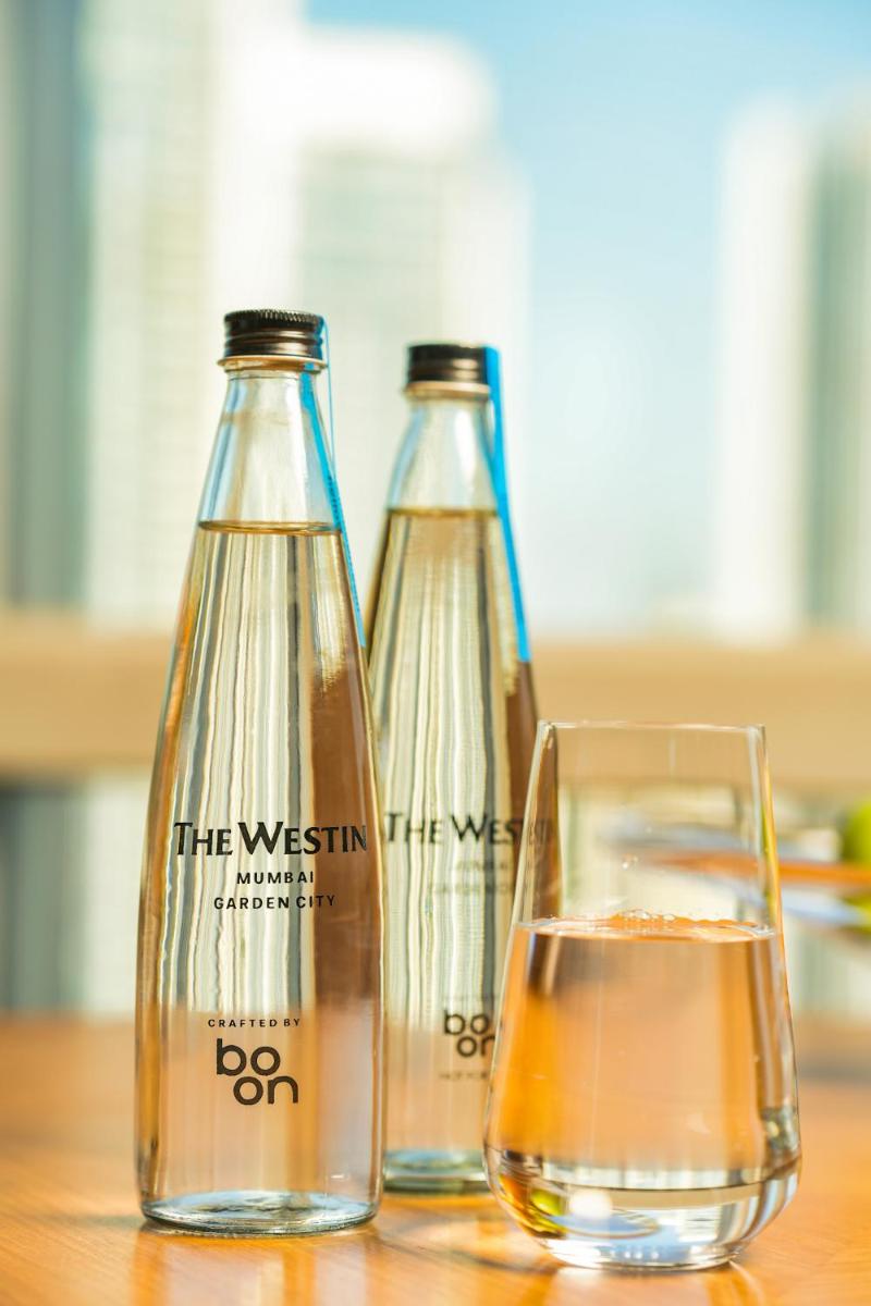 three bottles of water and a glass on a table at The Westin Mumbai Garden City in Mumbai