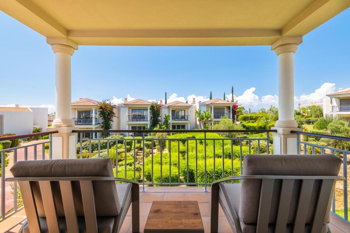 uma varanda com duas cadeiras e vista para os condomínios em Vale da Lapa Village Resort em Carvoeiro