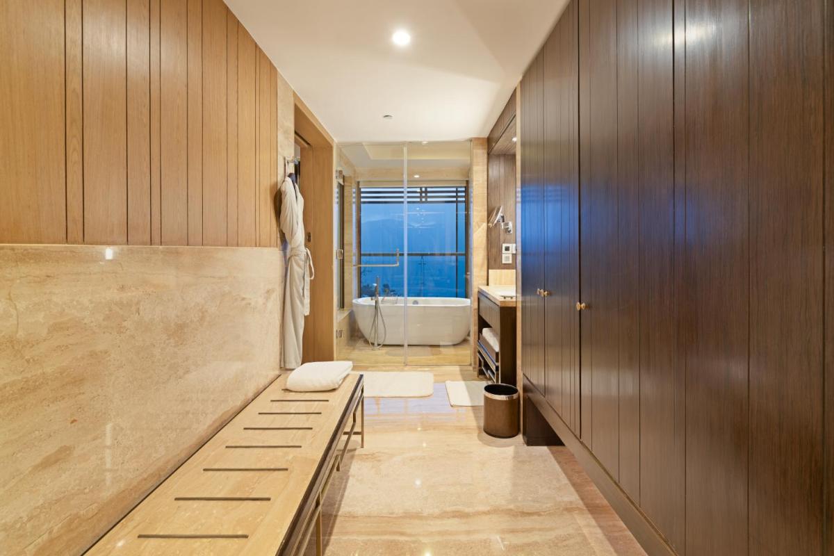 a bathroom with a bench and a bath tub at JW Marriott Mussoorie Walnut Grove Resort & Spa in Mussoorie