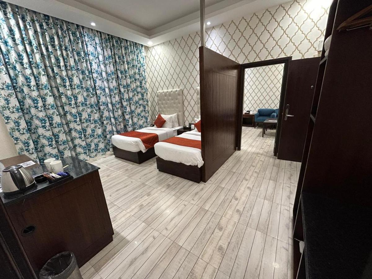 a hotel room with two beds and a bathroom at The Orchid Shimla in Shimla
