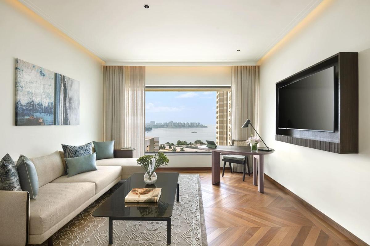 a living room with a couch and a flat screen tv at The Oberoi Mumbai in Mumbai
