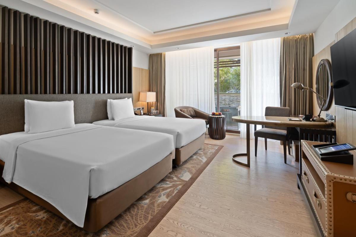 a hotel room with a large bed and a desk at JW Marriott Mussoorie Walnut Grove Resort & Spa in Mussoorie