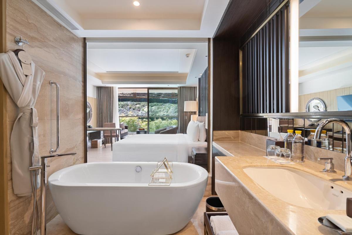 a bathroom with a large tub and a sink at JW Marriott Mussoorie Walnut Grove Resort & Spa in Mussoorie