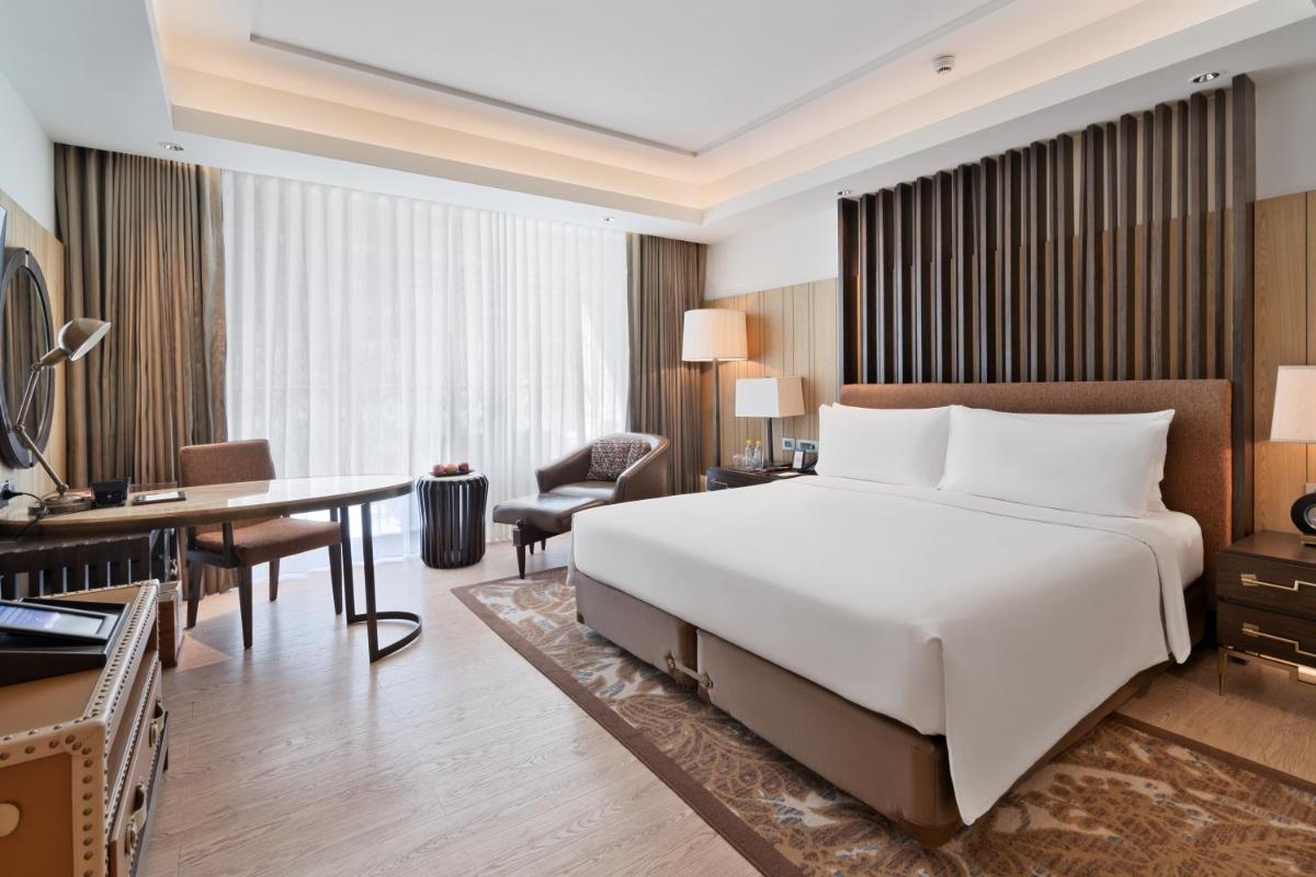 a hotel room with a large bed and a desk at JW Marriott Mussoorie Walnut Grove Resort & Spa in Mussoorie