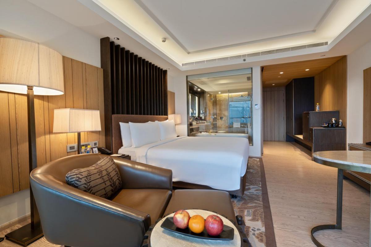 a hotel room with a bed and a couch at JW Marriott Mussoorie Walnut Grove Resort & Spa in Mussoorie