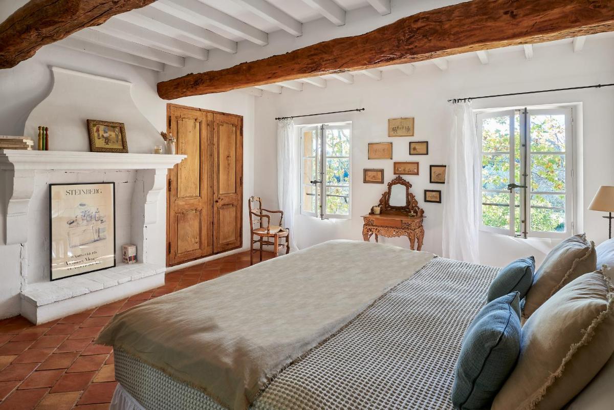 une chambre avec un lit et une cheminée dans l'établissement Château de Berne, à Lorgues