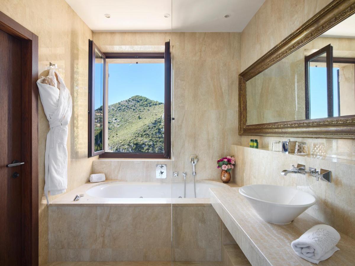une salle de bain avec une baignoire, un lavabo et une fenêtre dans l'établissement Chateau Eza, à Èze