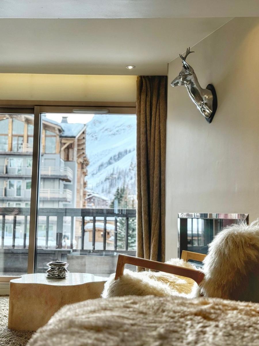un salon avec une tête de cerf sur le mur dans l'établissement Hotel Tsanteleina, à Val dʼIsère