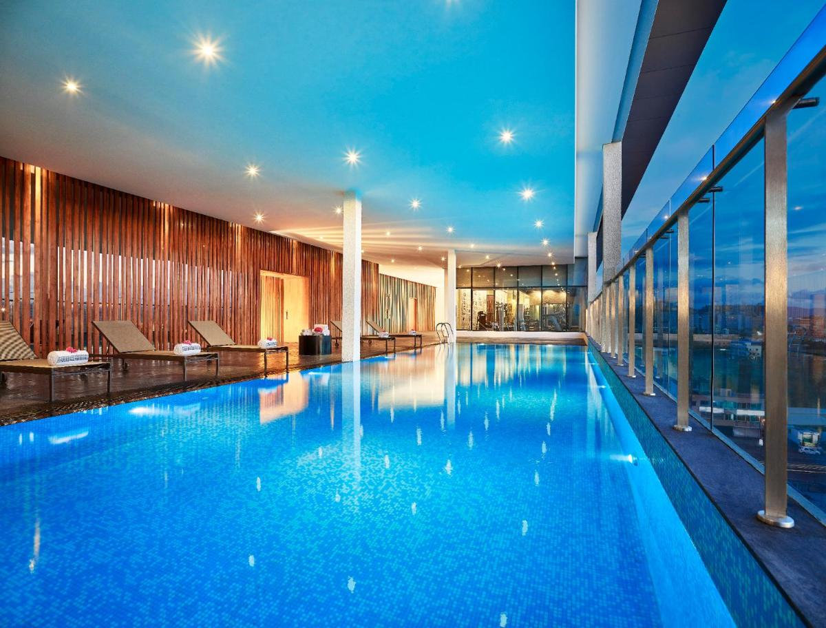 a large swimming pool with blue water in a building at Vivanta Pune, Hinjawadi in Pune