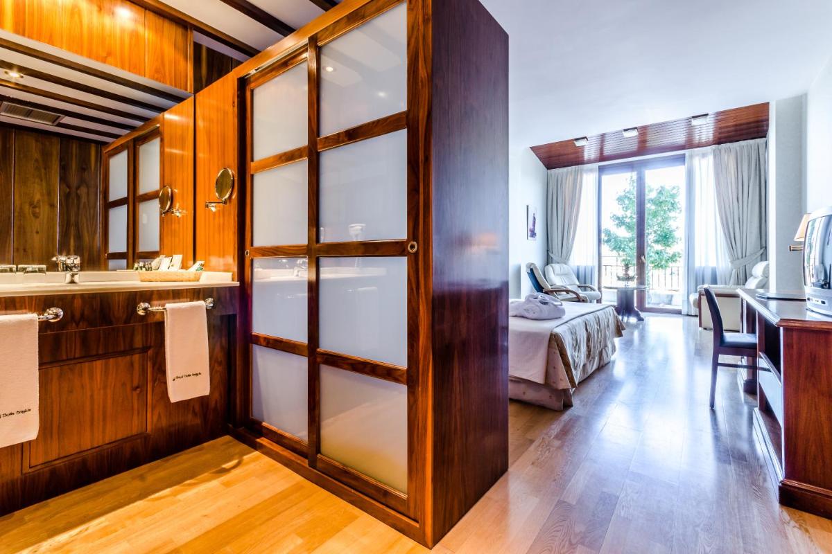 Un baño con una puerta corrediza de vidrio que conduce a un dormitorio. en Hotel Doña Brígida – Salamanca Forum, en Villamayor