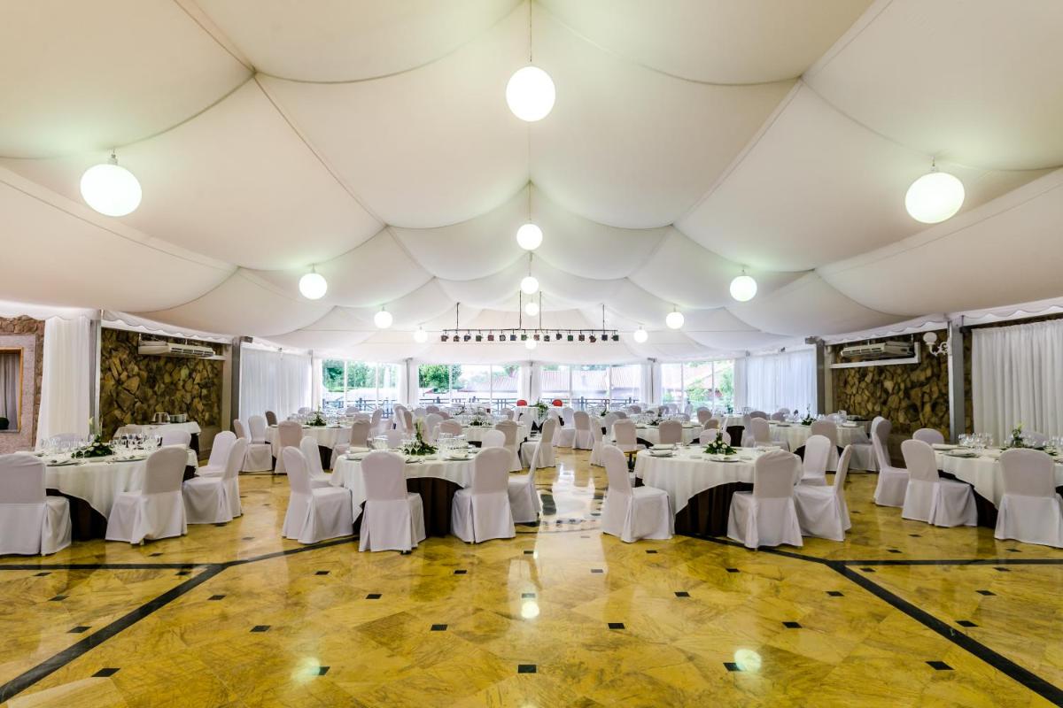 Un salón de banquetes con mesas y sillas blancas. en Hotel Doña Brígida – Salamanca Forum, en Villamayor 64 fotos más