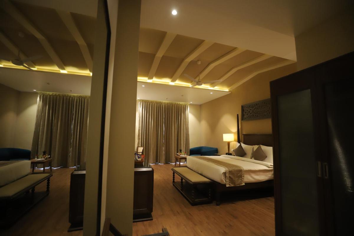 a hotel room with a bed and a couch at Essentia Luxury Resort & Spa Udaipur in Udaipur