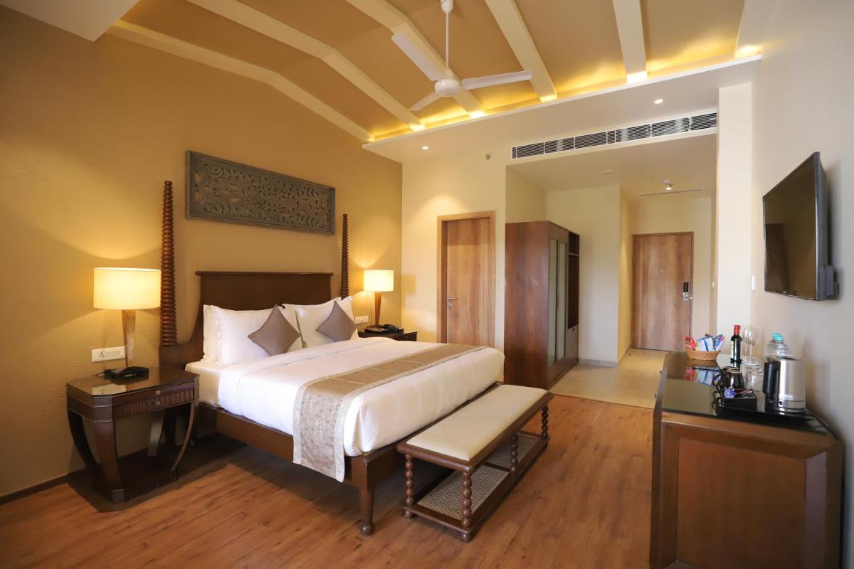 a bedroom with a large bed and a television at Essentia Luxury Resort & Spa Udaipur in Udaipur