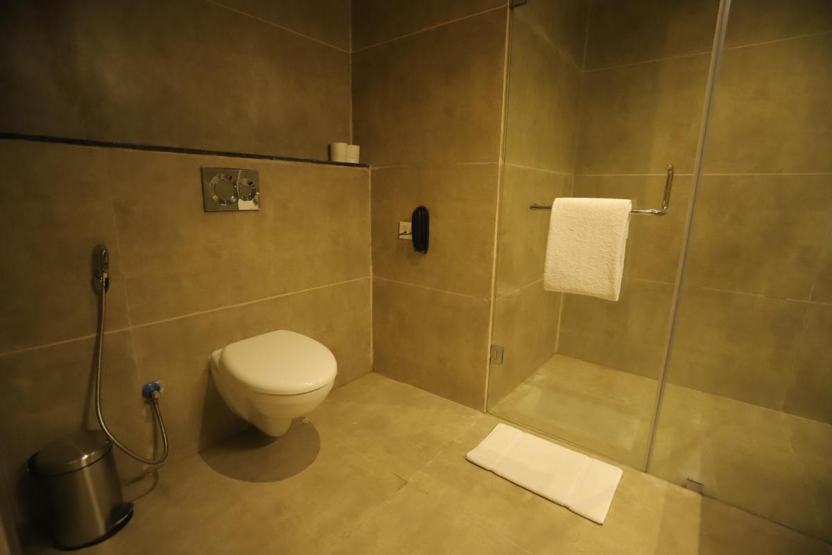 a bathroom with a toilet and a shower at Essentia Luxury Resort & Spa Udaipur in Udaipur