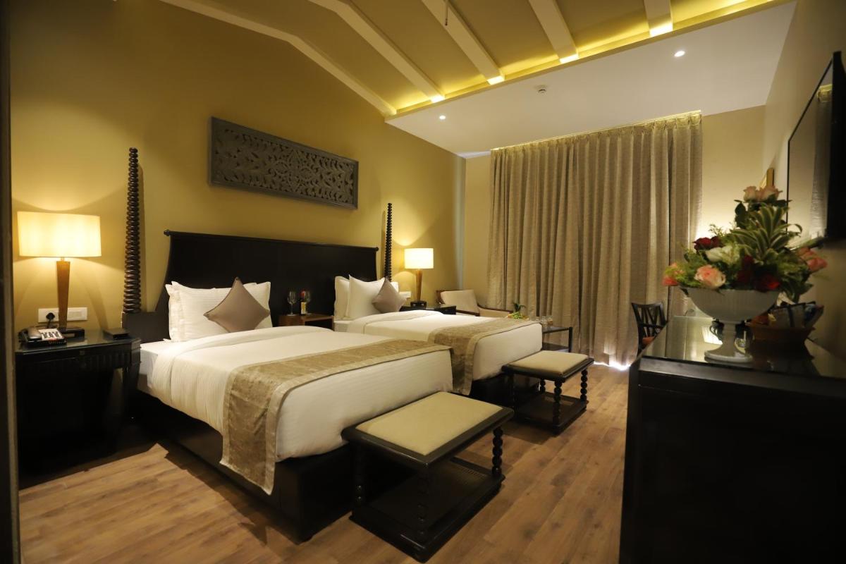 a large hotel room with two beds and a table at Essentia Luxury Resort & Spa Udaipur in Udaipur