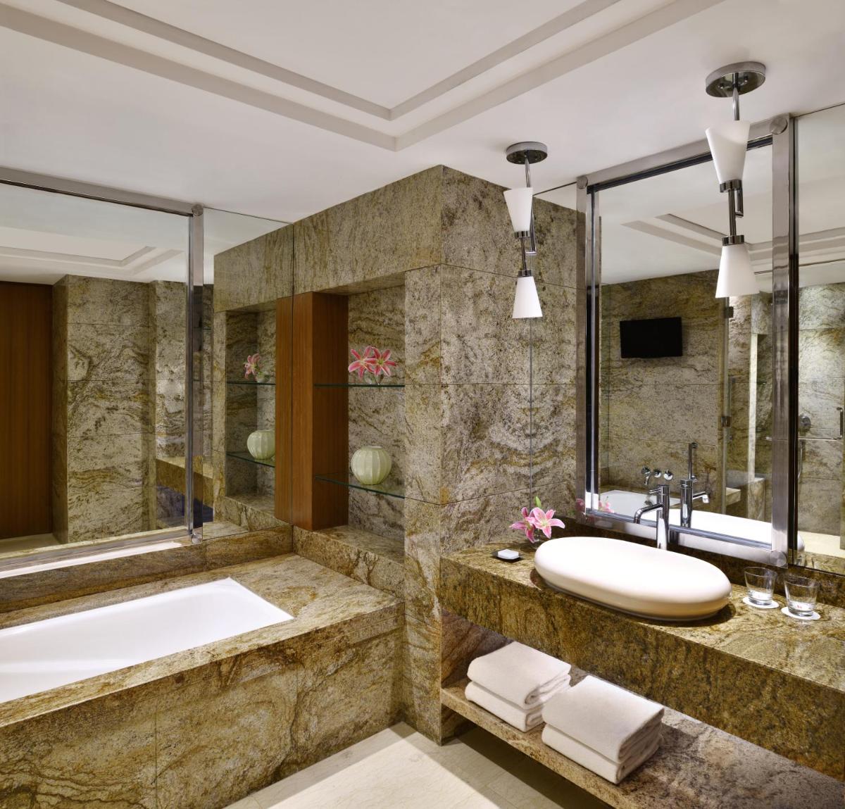 a bathroom with a tub and a sink at Bengaluru Marriott Hotel Whitefield in Bengaluru