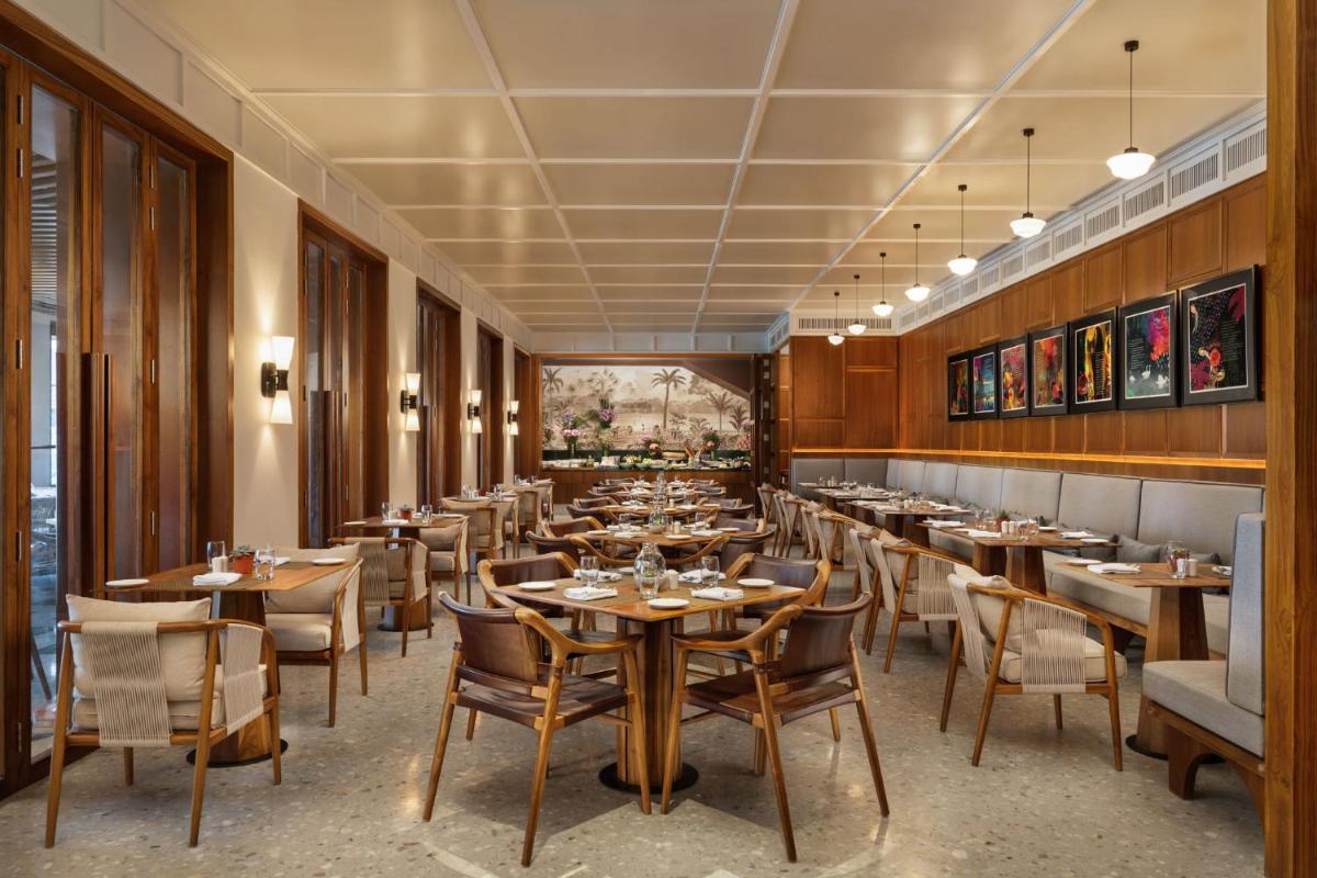 a restaurant with wooden walls and tables and chairs at Taj Taal Kutir in Kolkata