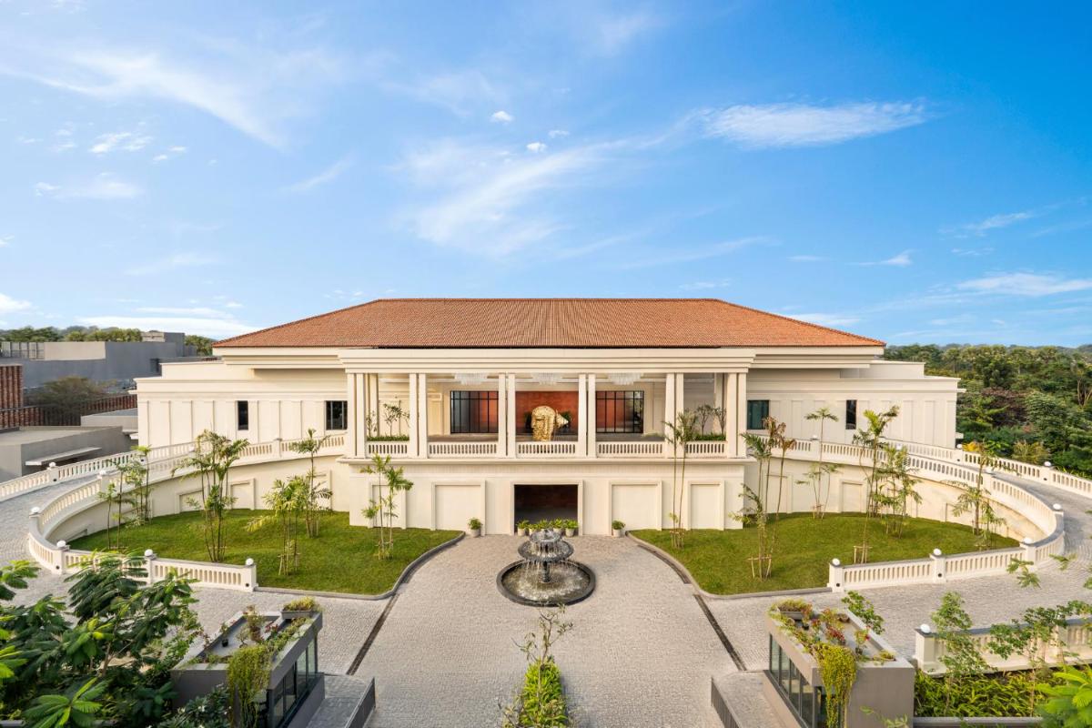 a large white house with a fountain in a courtyard at Taj Taal Kutir in Kolkata a large white house with a fountain in a courtyard at Taj Taal Kutir in Kolkata