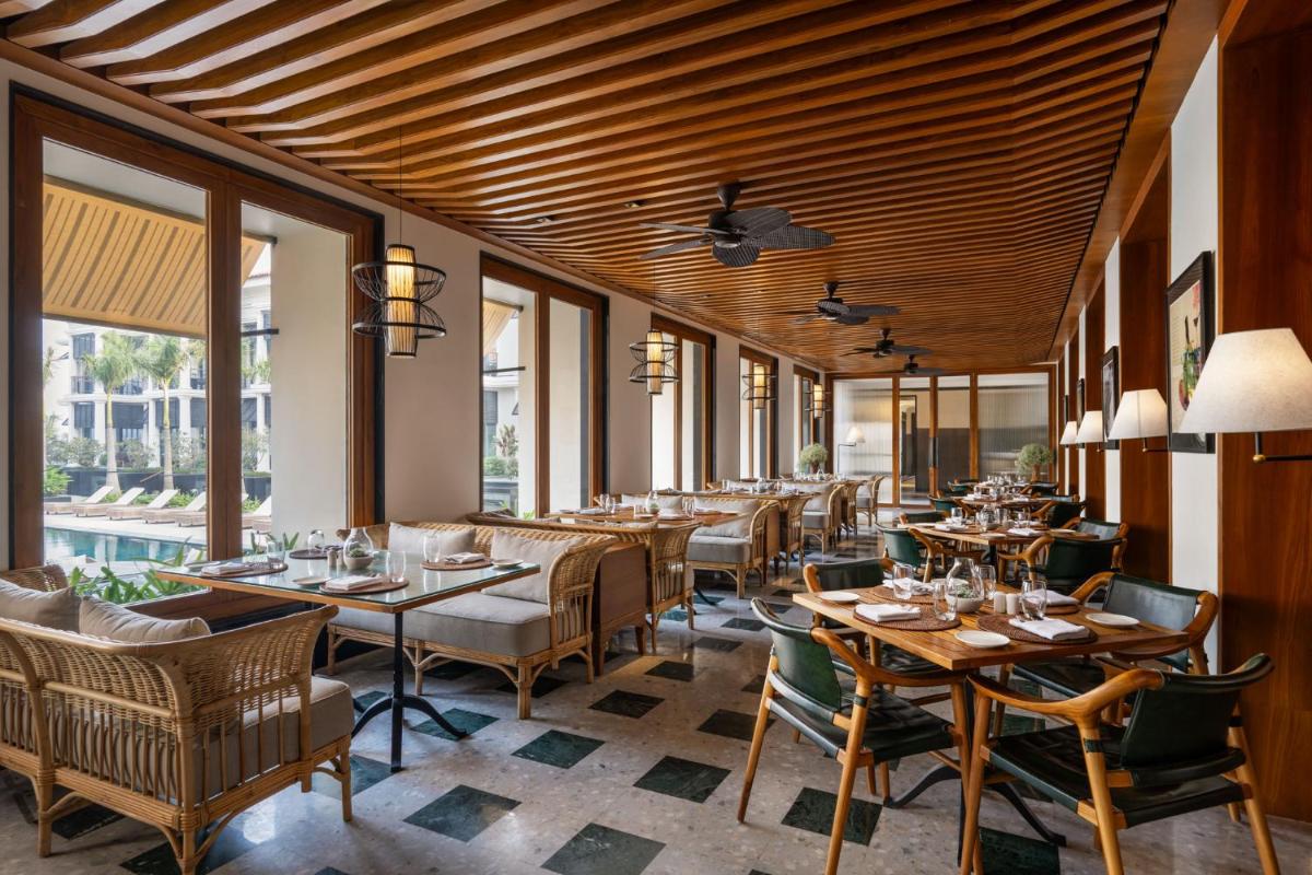 a restaurant with wooden ceilings and tables and chairs at Taj Taal Kutir in Kolkata