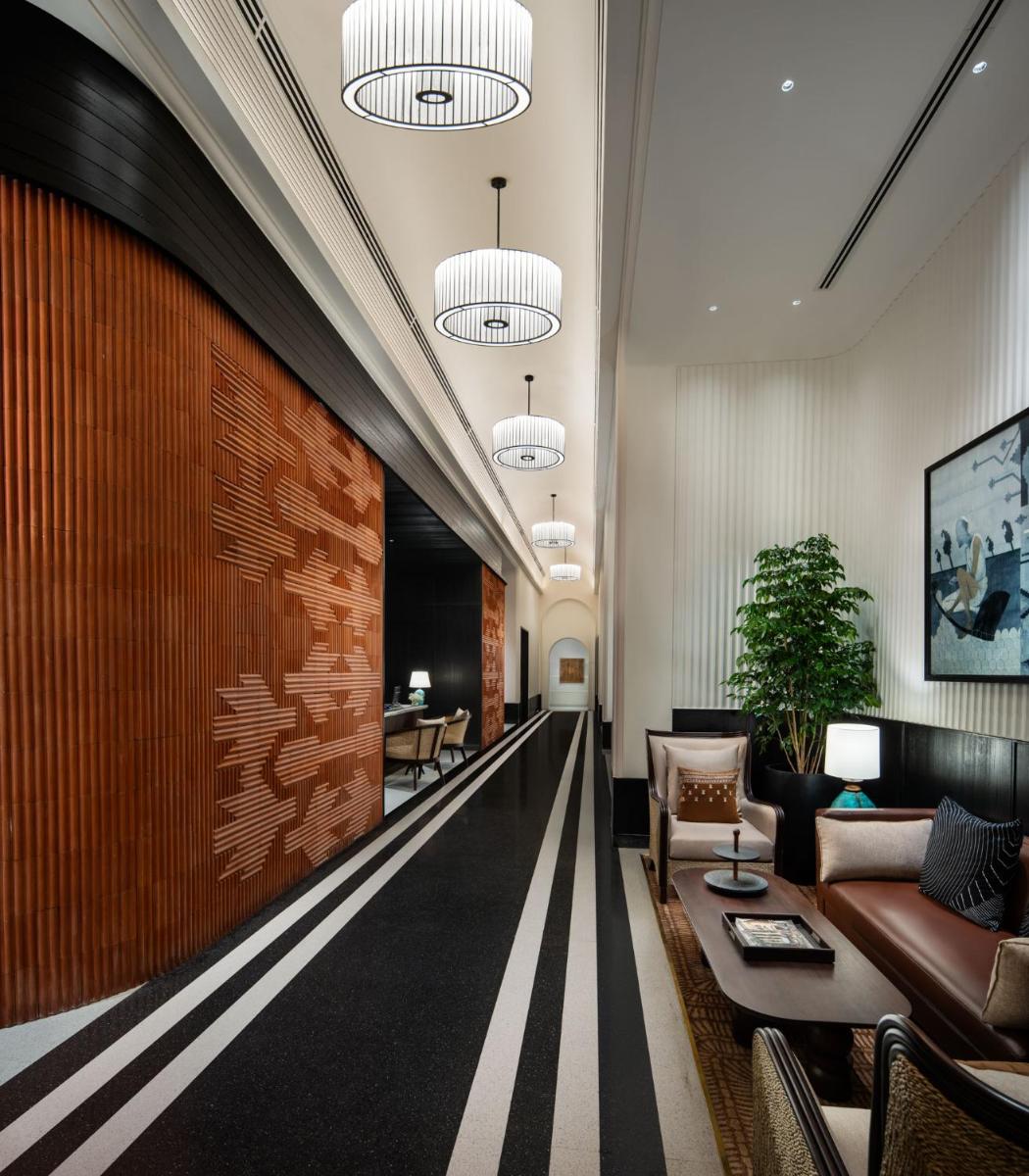 a lobby with a long hallway with couches and tables at Taj Taal Kutir in Kolkata