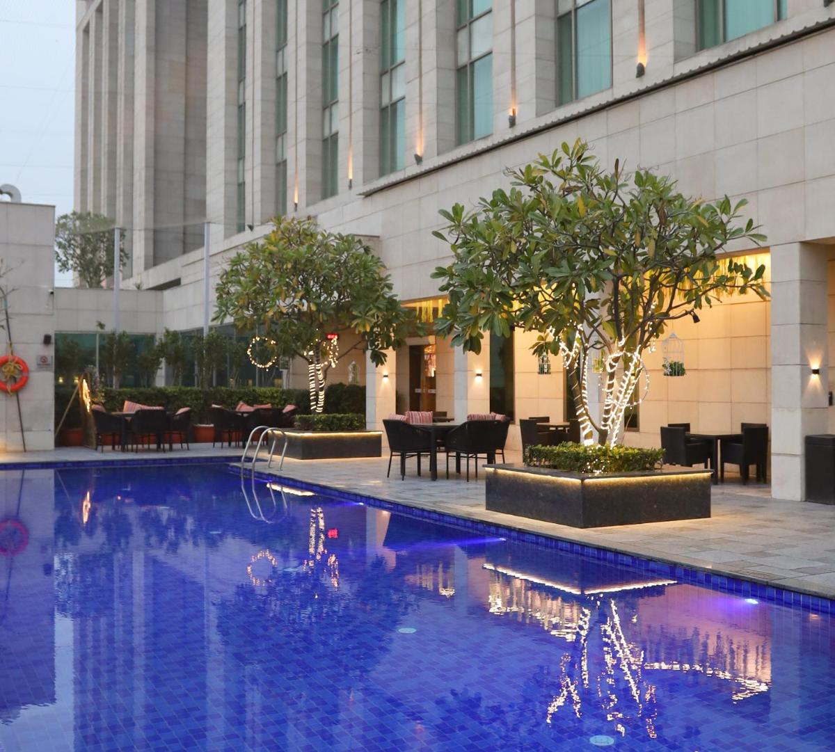 a swimming pool in front of a building at Crowne Plaza New Delhi Okhla by IHG in New Delhi