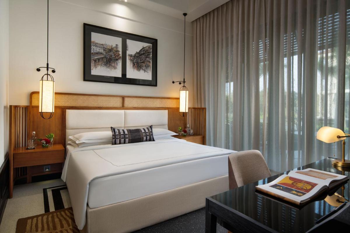a bedroom with a large white bed and a table at Taj Taal Kutir in Kolkata