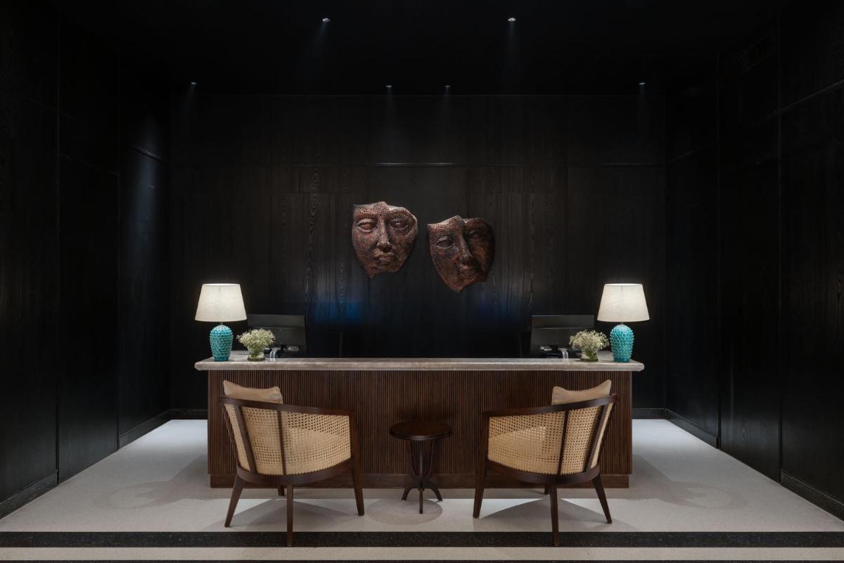 a room with a table and two masks on the wall at Taj Taal Kutir in Kolkata