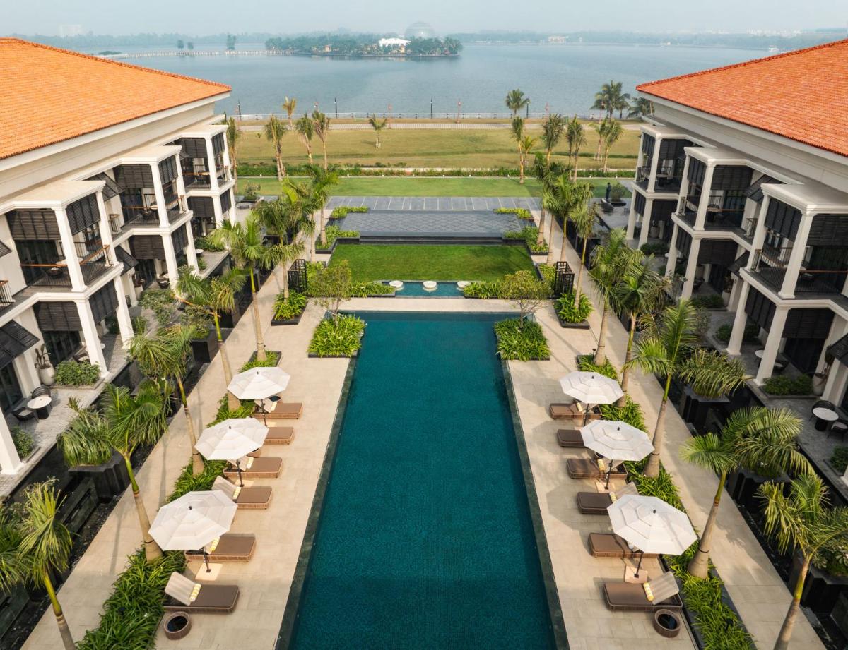 an aerial view of a resort pool with umbrellas and chairs at Taj Taal Kutir in Kolkata