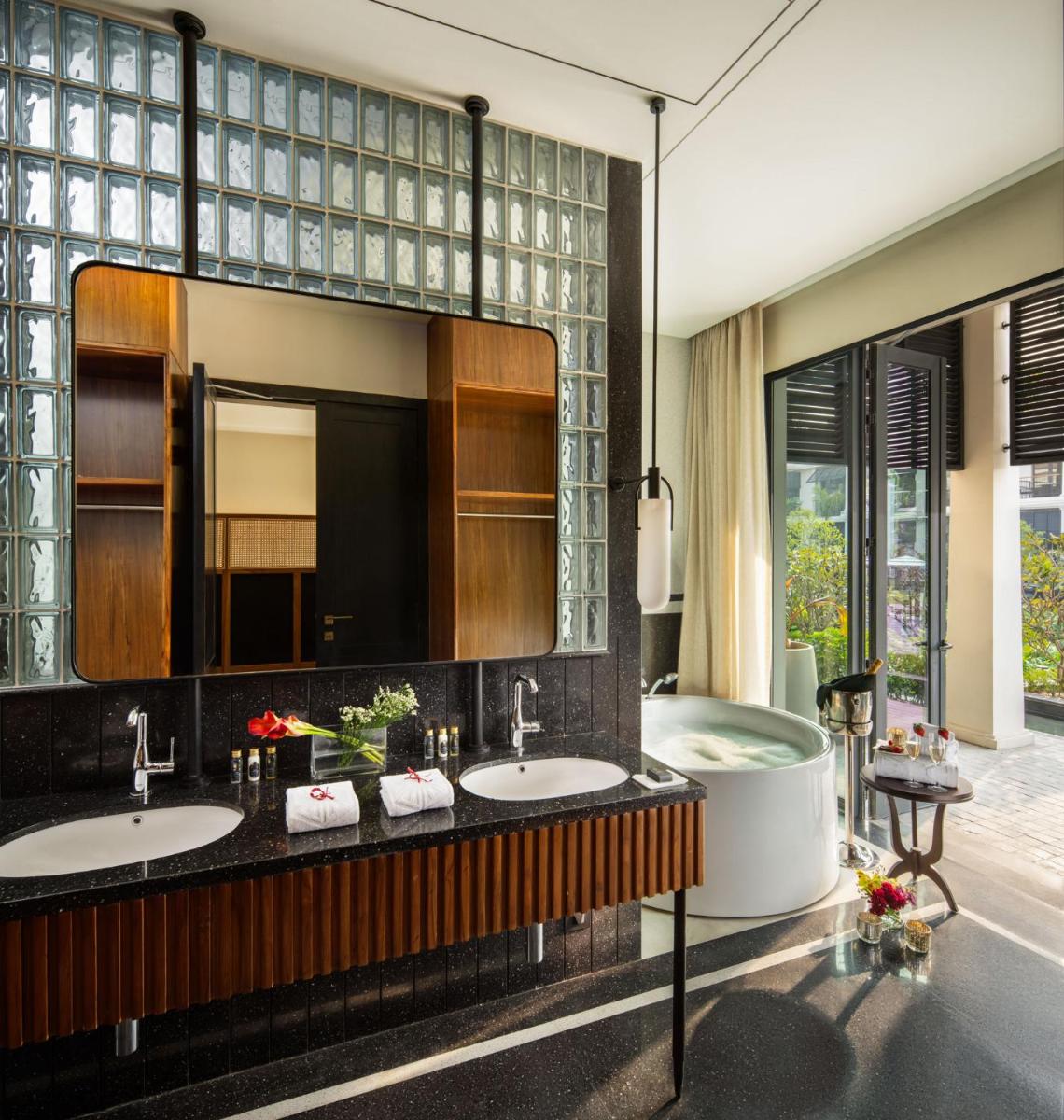 a bathroom with two sinks and a tub and a mirror at Taj Taal Kutir in Kolkata