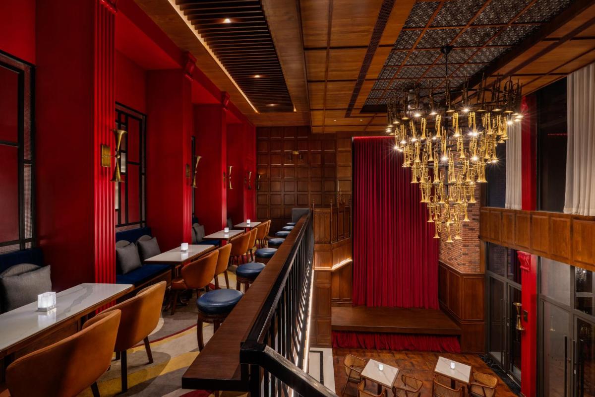 a restaurant with red walls and tables and a chandelier at Taj Taal Kutir in Kolkata