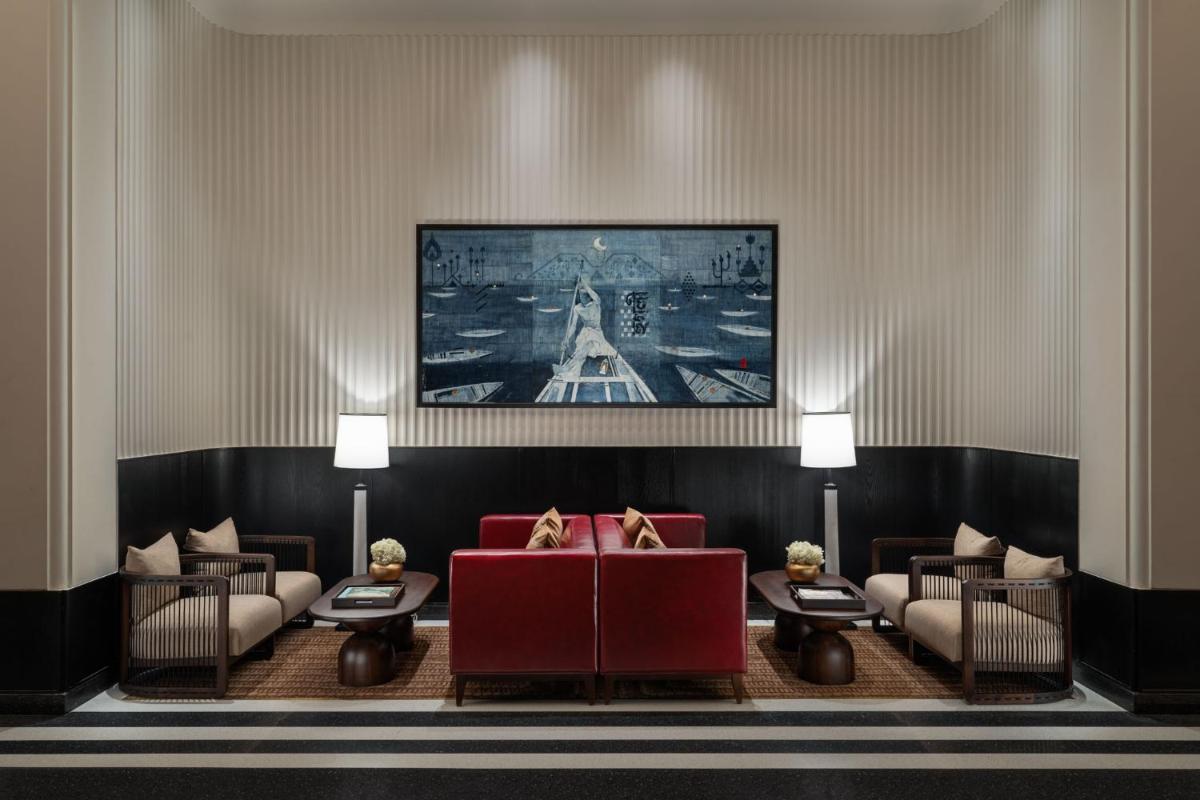a living room with couches and a painting on the wall at Taj Taal Kutir in Kolkata