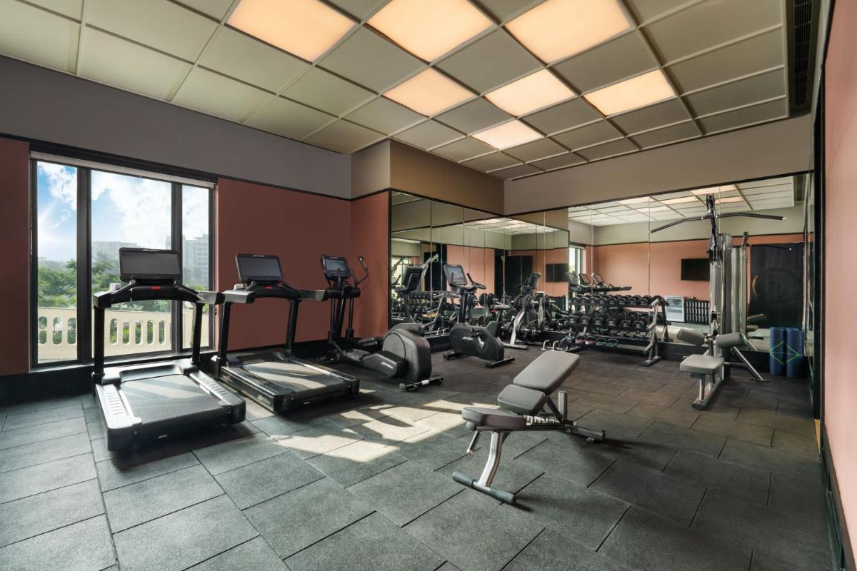 a gym with treadmills and ellipticals in a building at Taj Taal Kutir in Kolkata