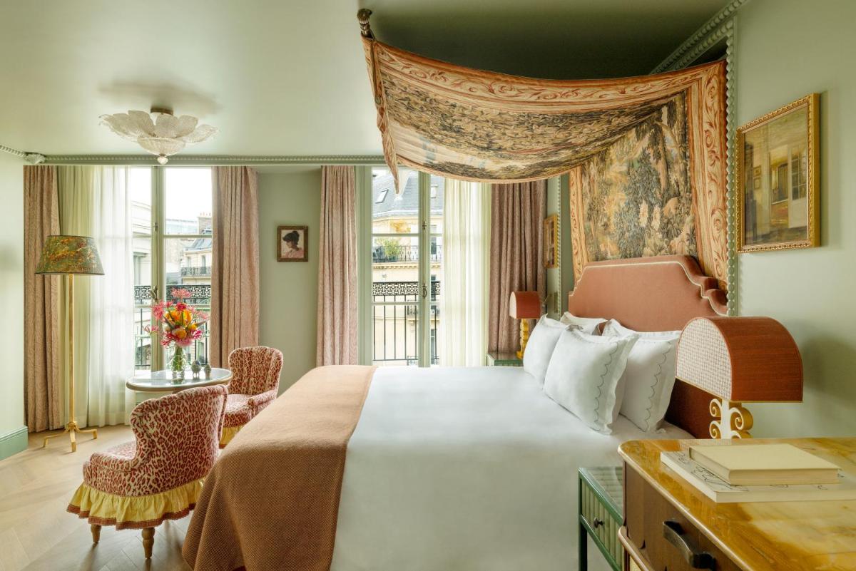 une chambre avec un grand lit et une fenêtre dans l'établissement Le Grand Mazarin, à Paris