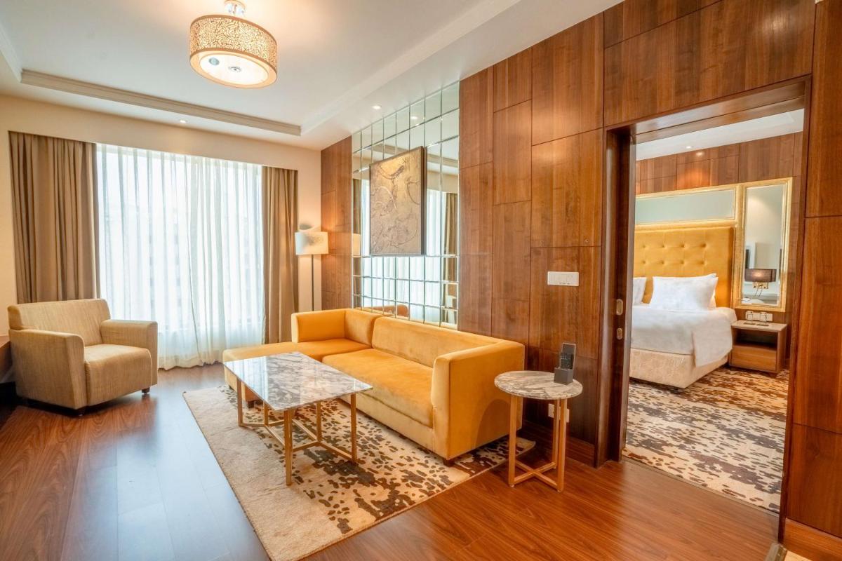 a living room with a couch and a bed at Radisson Blu Pune Hinjawadi in Pune a living room with a couch and a bed at Radisson Blu Pune Hinjawadi in Pune
