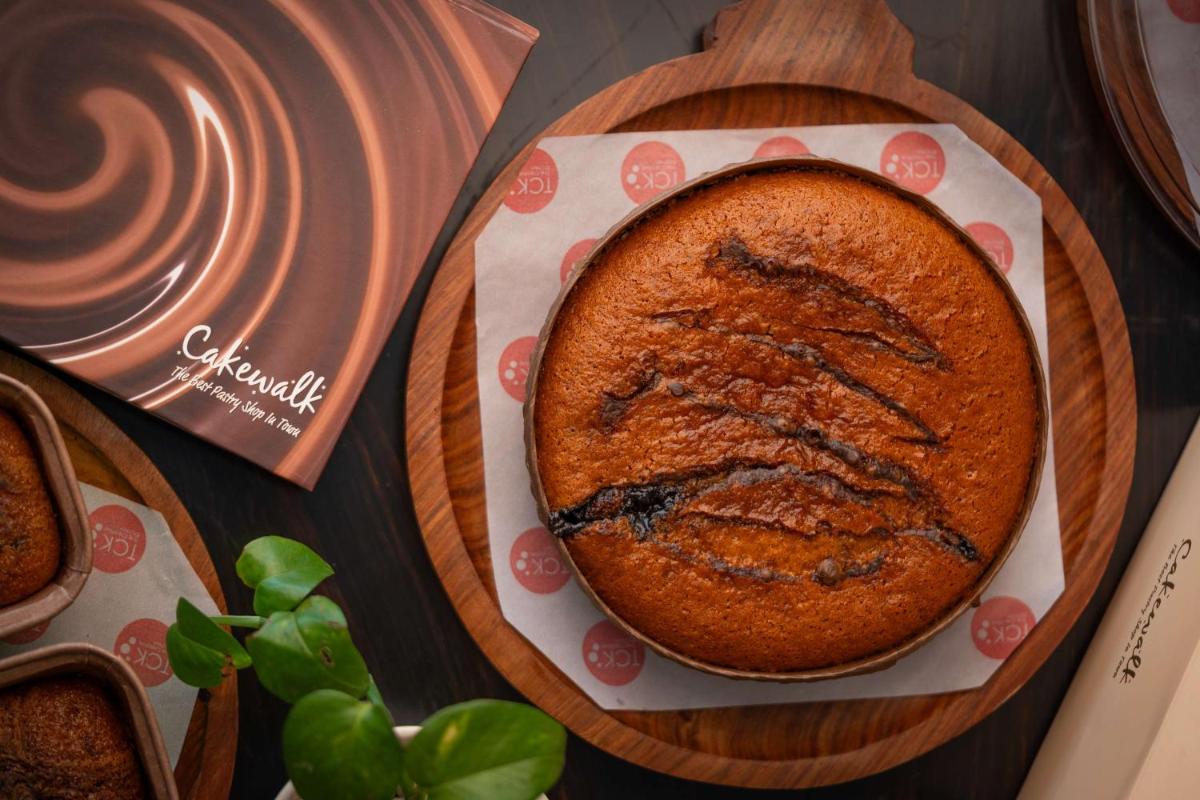 a cake on a plate on a wooden cutting board at Radisson Blu Hotel, Indore in Indore