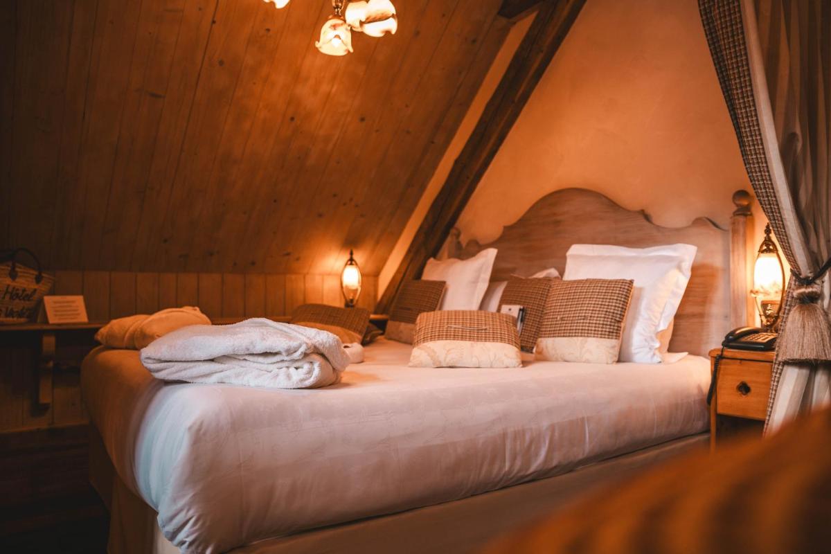 Un ou plusieurs lits dans un hébergement de l'établissement Les Violettes Hotel & Spa