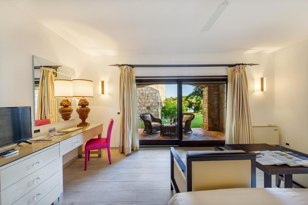 Cette chambre d'hôtel dispose d'un bureau, d'une table et de chaises. dans l'établissement Hotel & SPA des Pecheurs, à Bonifacio