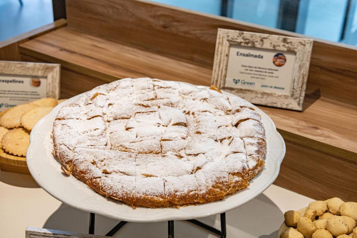un pastel en un plato blanco en un mostrador con galletas en Seth Port Ciutadella, en Ciutadella