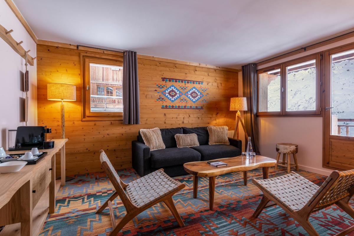 un salon avec un canapé et une table dans l'établissement Chalet Hotel Kaya, aux Menuires