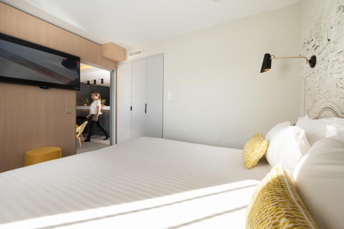 Un ou plusieurs lits dans un hébergement de l'établissement Nemea Appart Hotel Cannes Palais