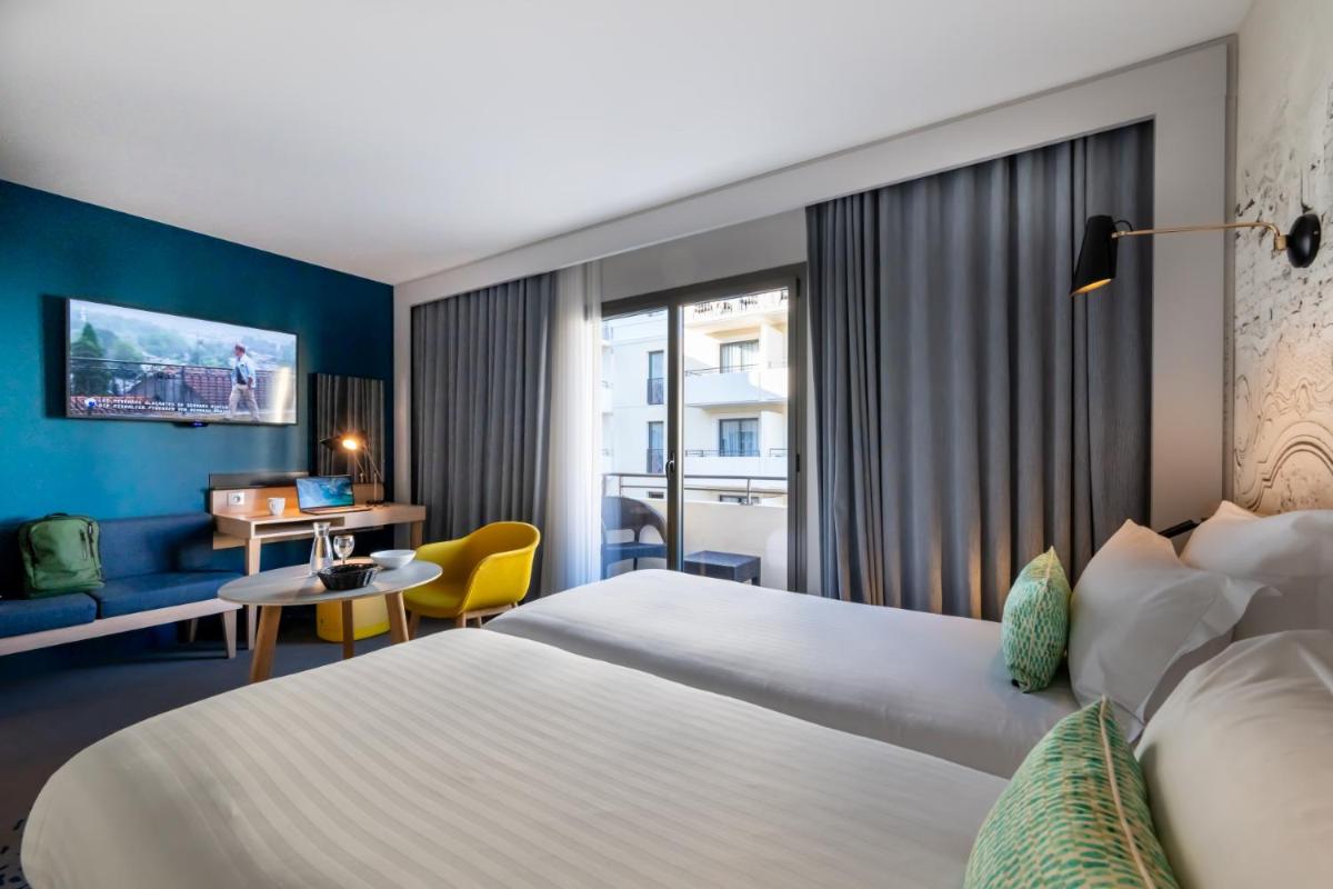 Un ou plusieurs lits dans un hébergement de l'établissement Nemea Appart Hotel Cannes Palais