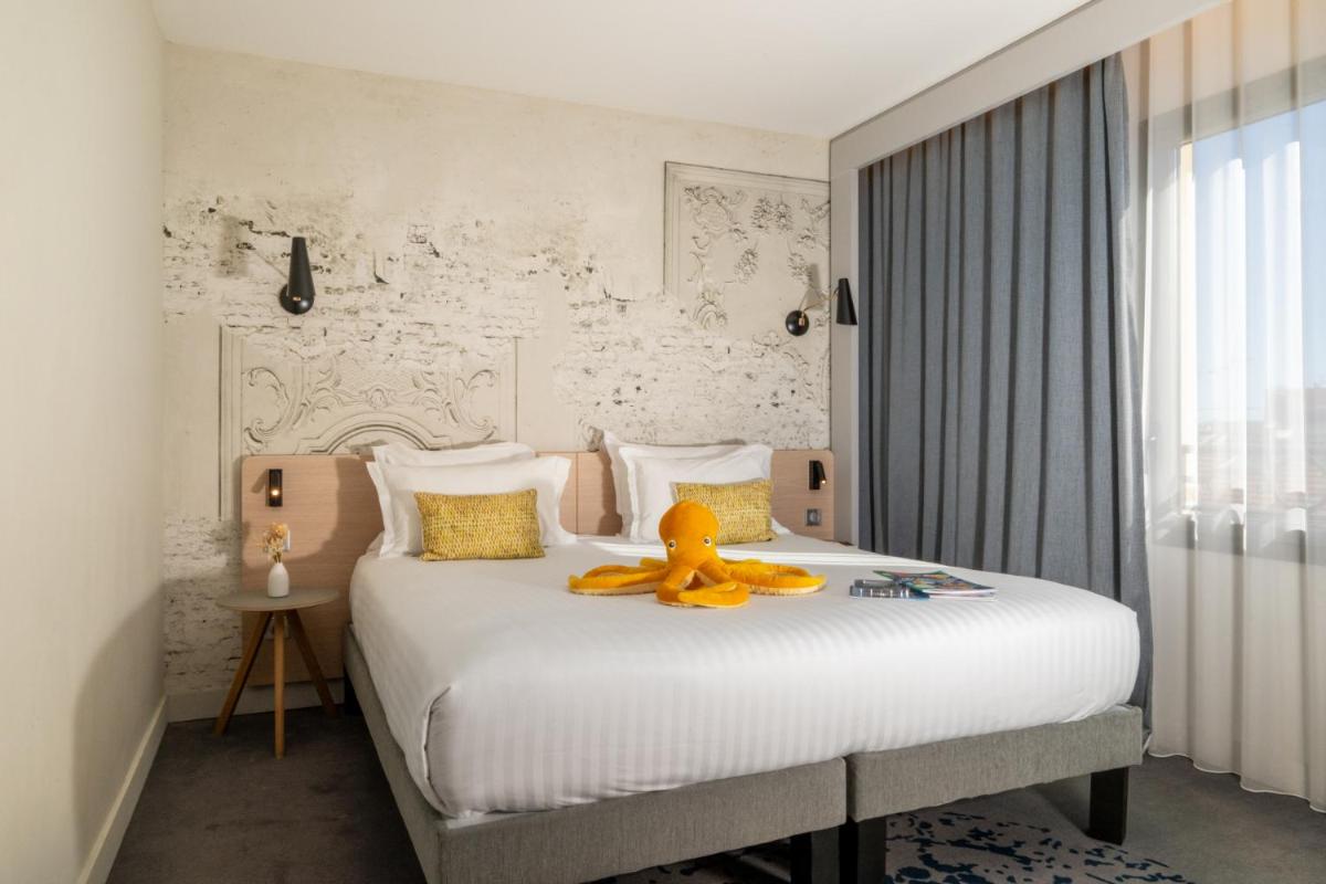 Un ou plusieurs lits dans un hébergement de l'établissement Nemea Appart Hotel Cannes Palais