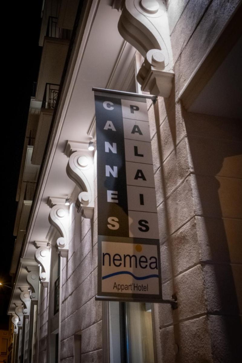 un panneau sur le côté d'un bâtiment dans l'établissement Nemea Appart Hotel Cannes Palais, à Cannes