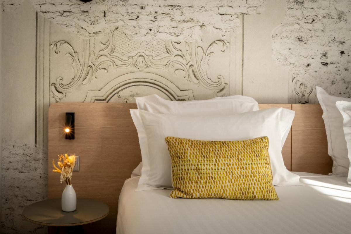 Un ou plusieurs lits dans un hébergement de l'établissement Nemea Appart Hotel Cannes Palais