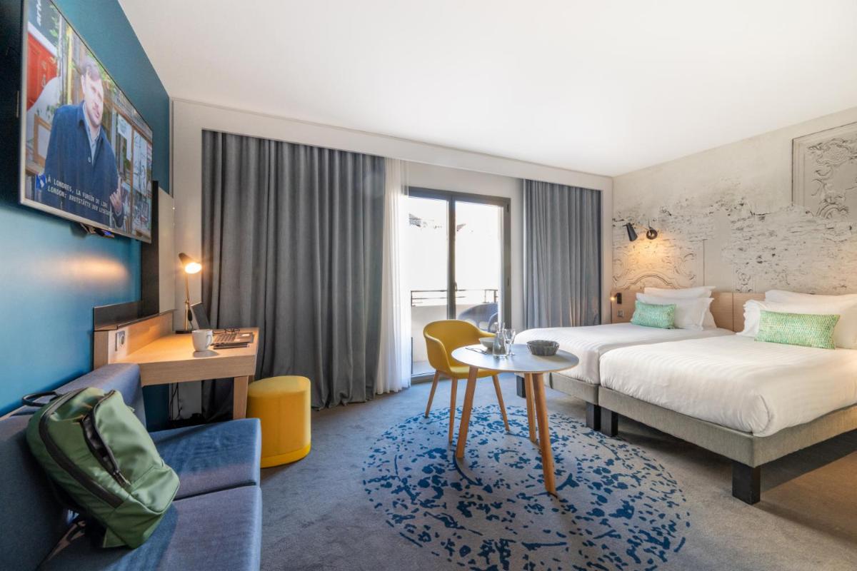Un ou plusieurs lits dans un hébergement de l'établissement Nemea Appart Hotel Cannes Palais