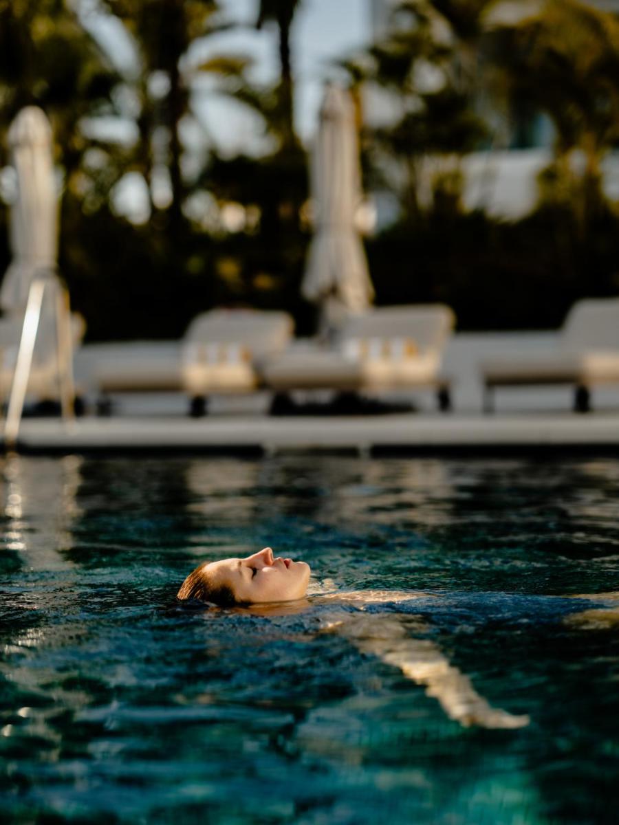 una mujer nadando en una piscina en el agua en THE FLAG HOTEL Marbella, Estepona Adult Recommended, en Estepona