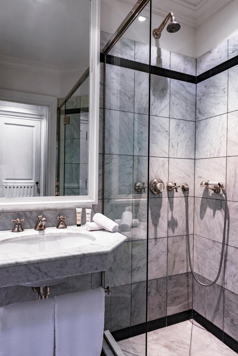 une salle de bain avec douche et lavabo dans l'établissement Le Dokhan's Paris Arc de Triomphe, a Tribute Portfolio Hotel, à Paris
