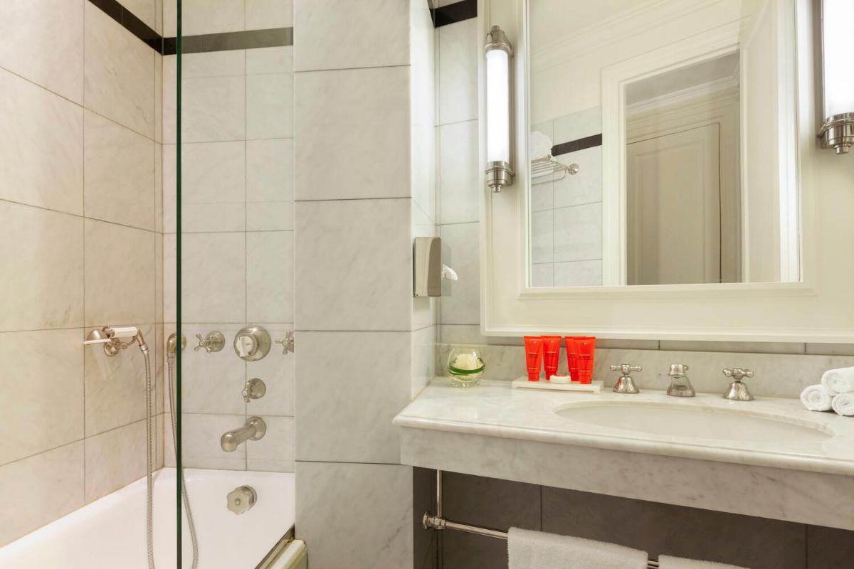 une salle de bain avec un lavabo et une douche dans l'établissement Le Dokhan's Paris Arc de Triomphe, a Tribute Portfolio Hotel, à Paris 37 autres photos