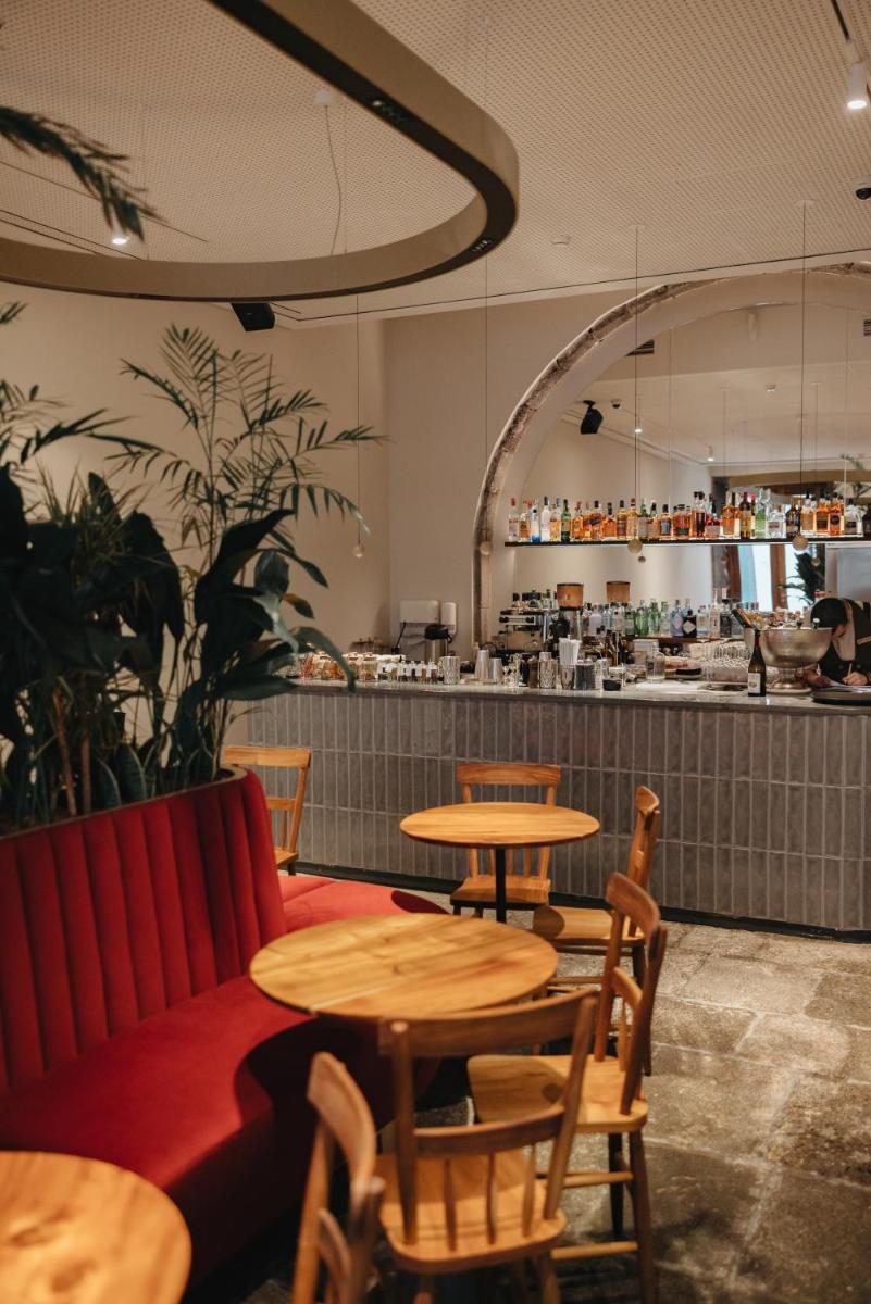 um restaurante com mesas, um sofá e um balcão em NINE DOTS Azorean Art Boutique Hotel em Ponta Delgada