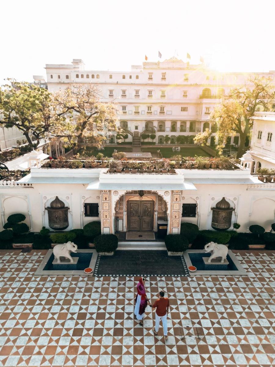 two people standing in front of a building at The Raj Palace (Small Luxury Hotels of the World) in Jaipur